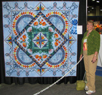 Sharon at Des Moines, standing with her quilt.